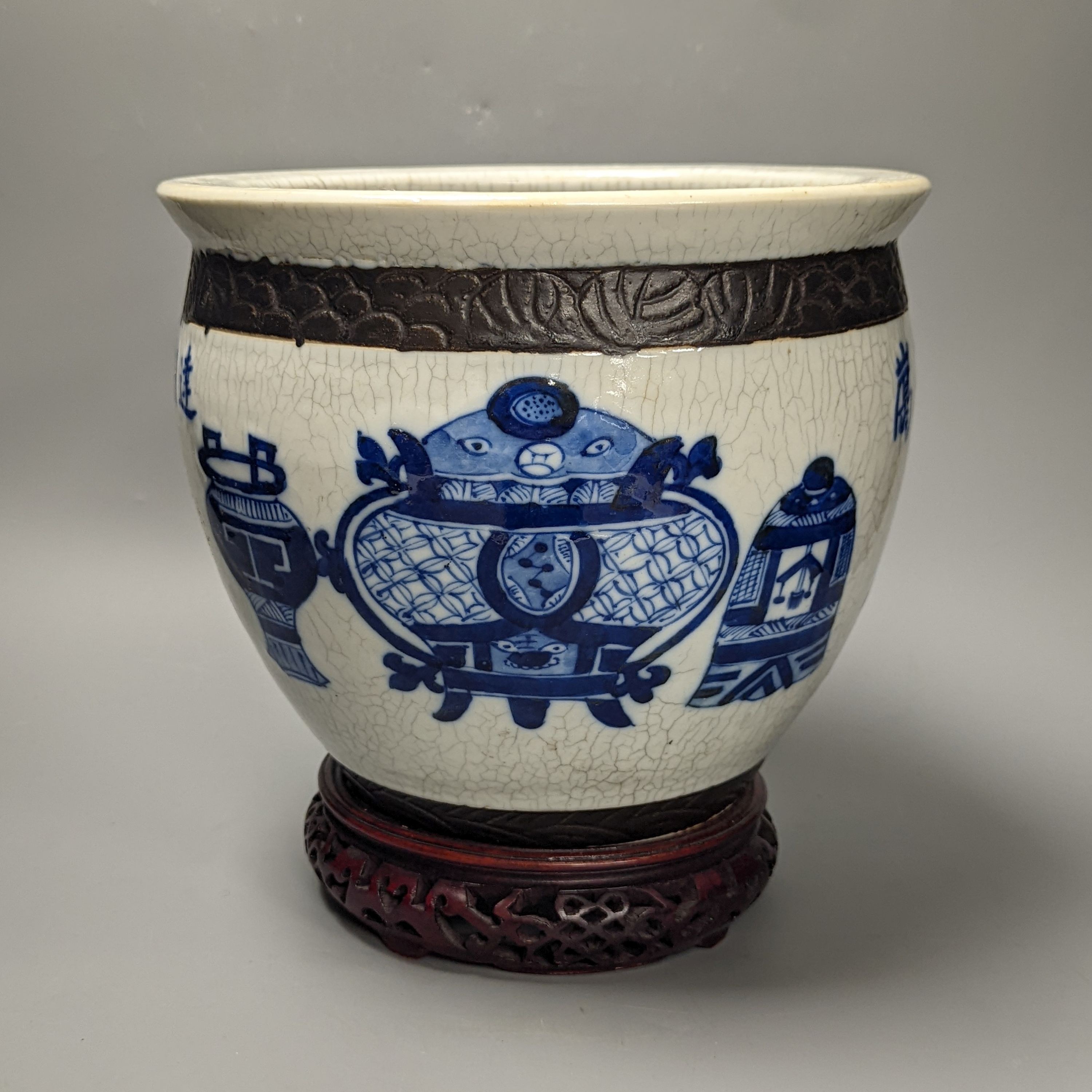 A Chinese blue and white crackle glazed jardiniere, early 20th century, wood stand. Total height 27cm